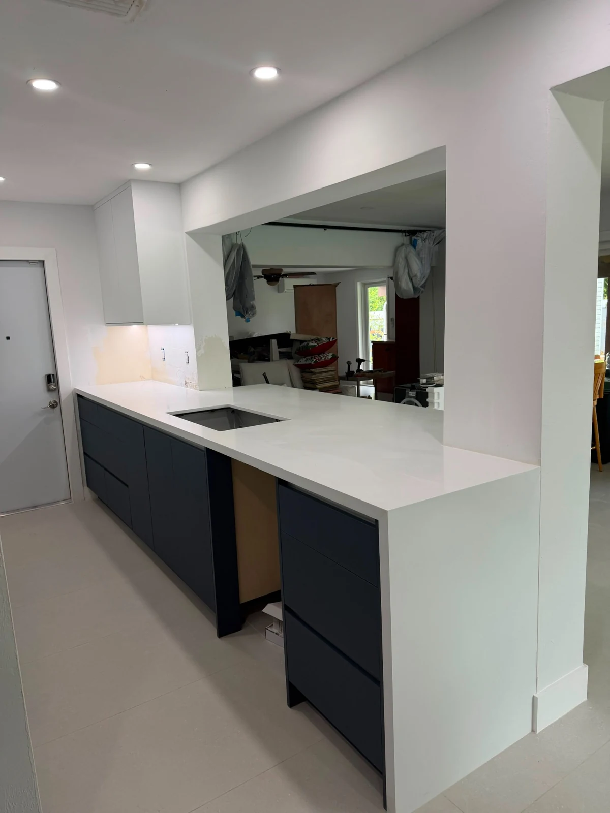 Side view of a white kitchen peninsula with navy base cabinets