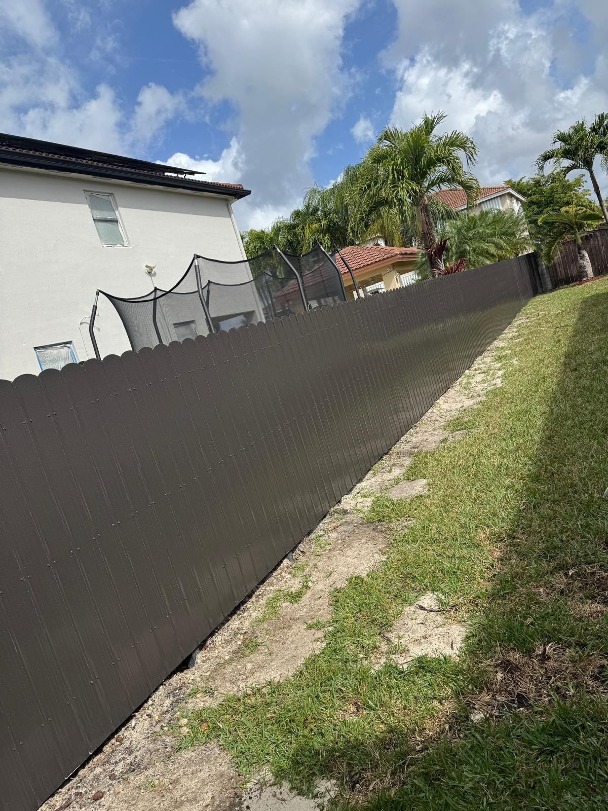 Fence extending along the side of a house