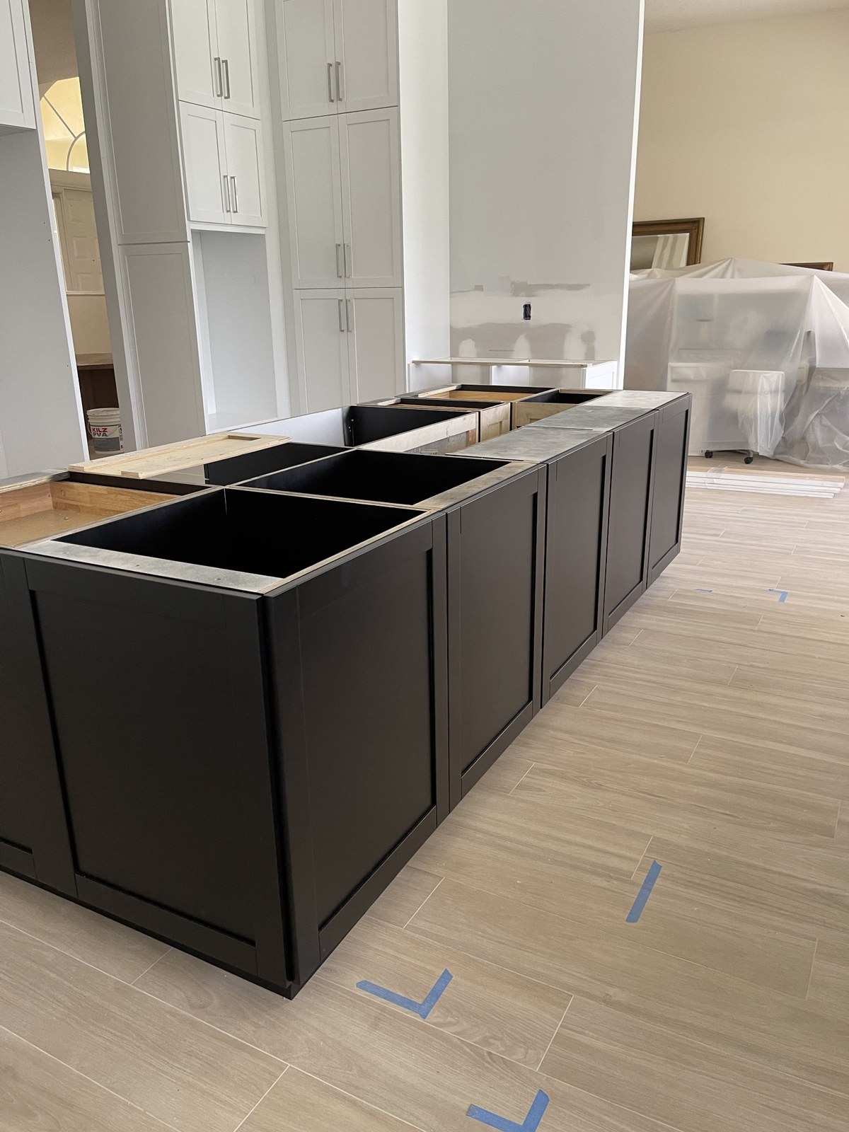 Wood-look plank flooring alongside an unfinished kitchen island during renovation