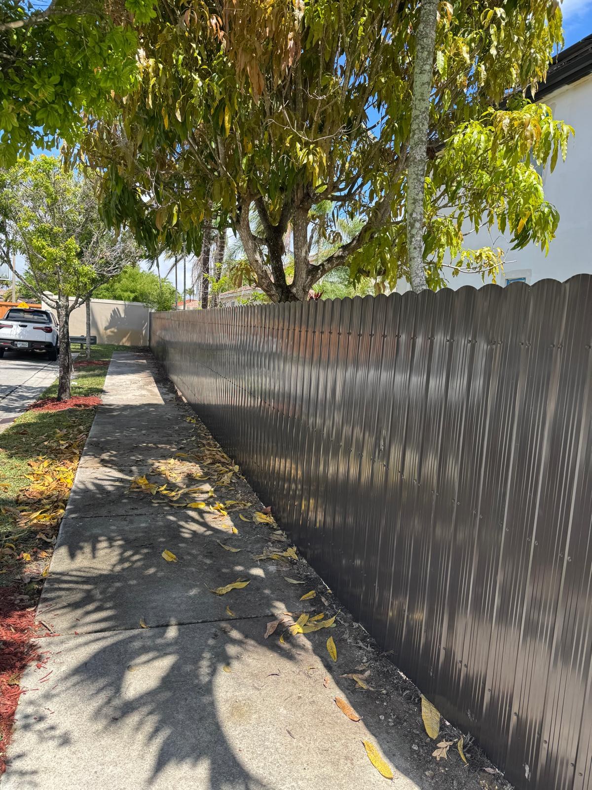 Closer view of a fence running alongside a sidewalk