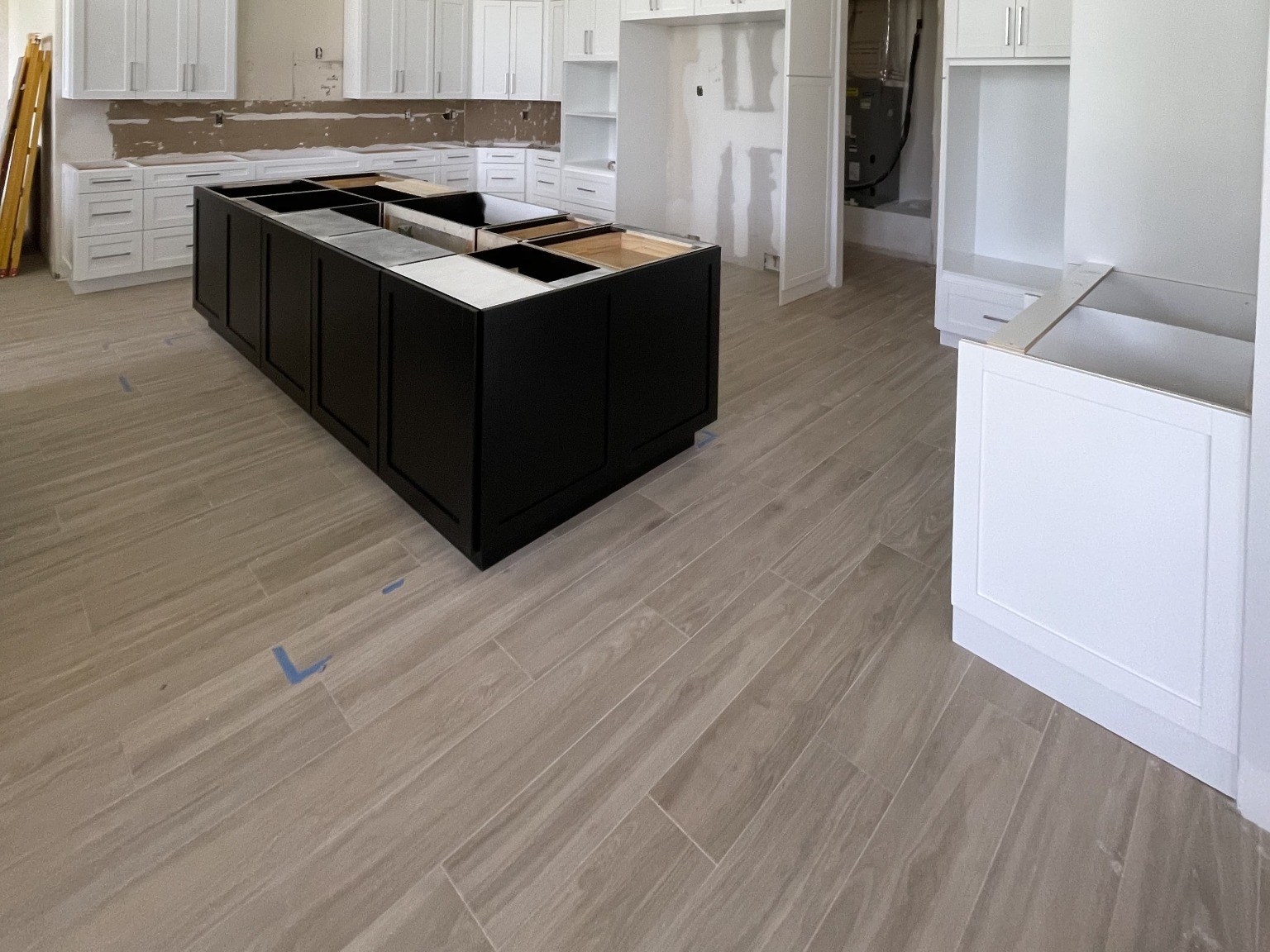 Wood-look plank flooring around a kitchen island during renovation